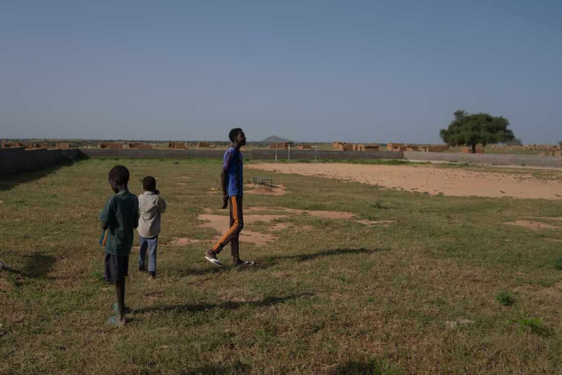 Mahamat DJouma, 14, with two of his younger brothers at the soccer field where he likes to play. He has nicknames for the boys: 