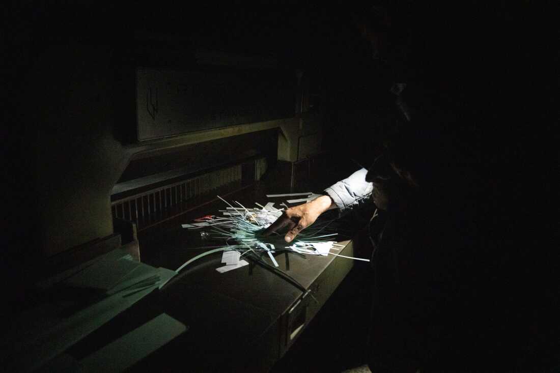 Moustafa sifts through shredded documents he finds in the former Air Force Intelligence building in Damascus.