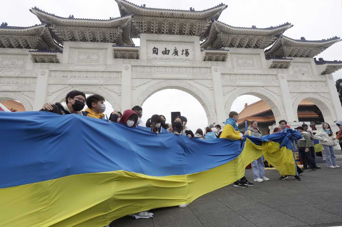 A group of Ukrainian people in Taiwan and supporters hold a Ukraine national flag during a protest, marking one year since the Russian invasion of Ukraine, at Liberty Square in Taipei, Taiwan, Saturday, Feb. 25, 2023.