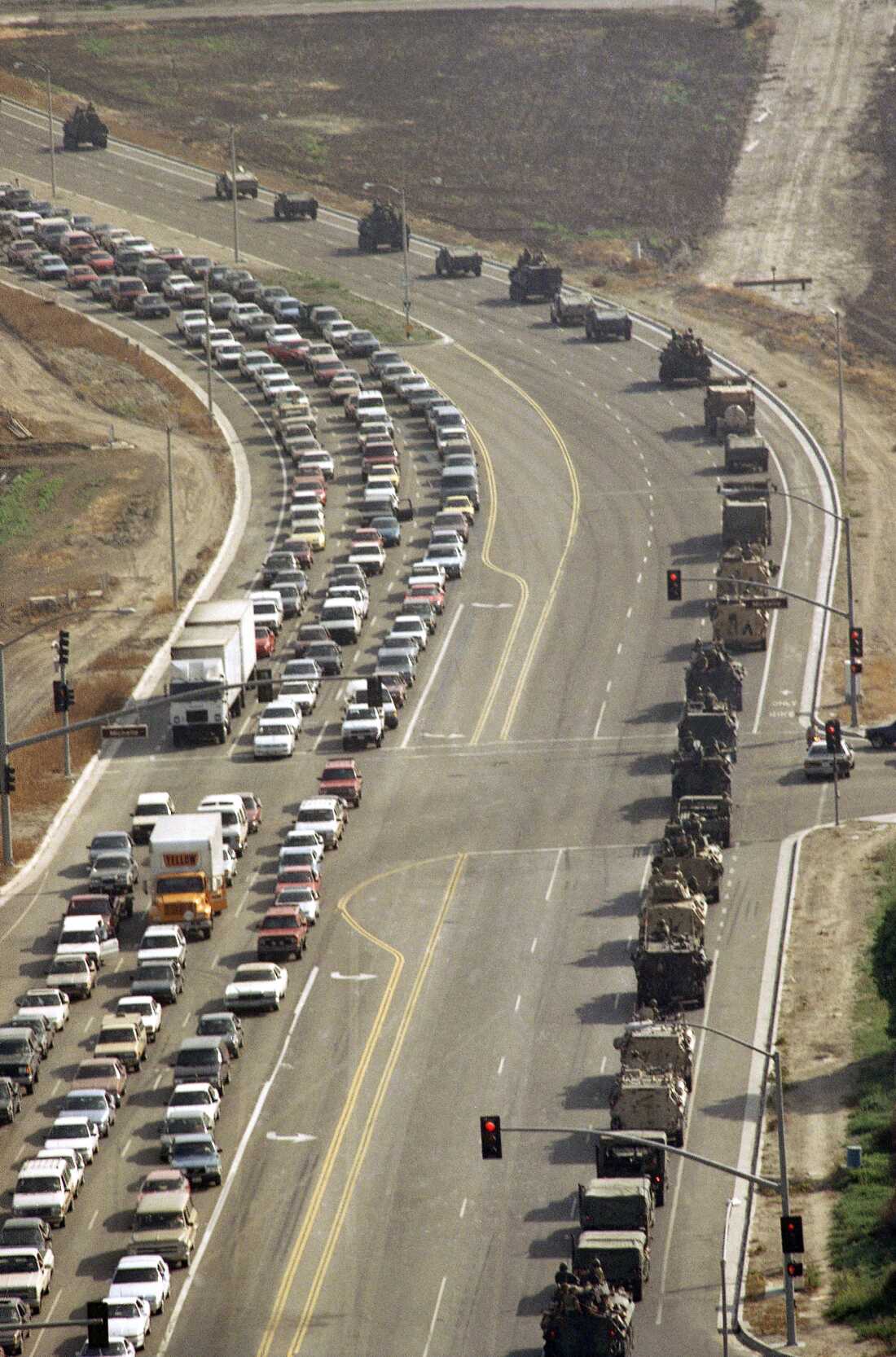 A convoy of U.S. Marines from Camp Pendleton in San Diego County (right) make there way to the U.S. Marine Corps Air Station in Tustin, California on May 1, 1992 as President George H.W. Bush ordered military units from the Army and the Marines to stand ready to help the police and the National Guard to restore order in Los Angeles.