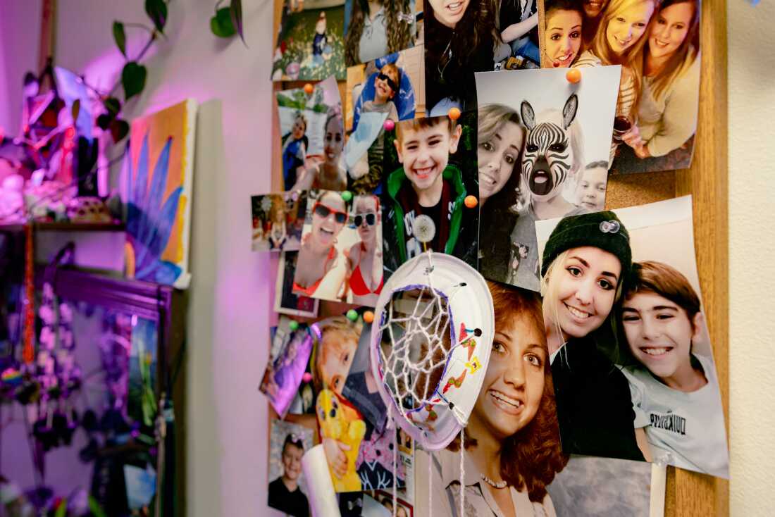 Photos of Becca Morris and her son, Jayden Dolly, along with other family members, are tacked to a bulletin board in her bedroom in Bridgeville, Delaware on Wednesday, May 14, 2025. (Wesley Lapointe/ for NPR)
