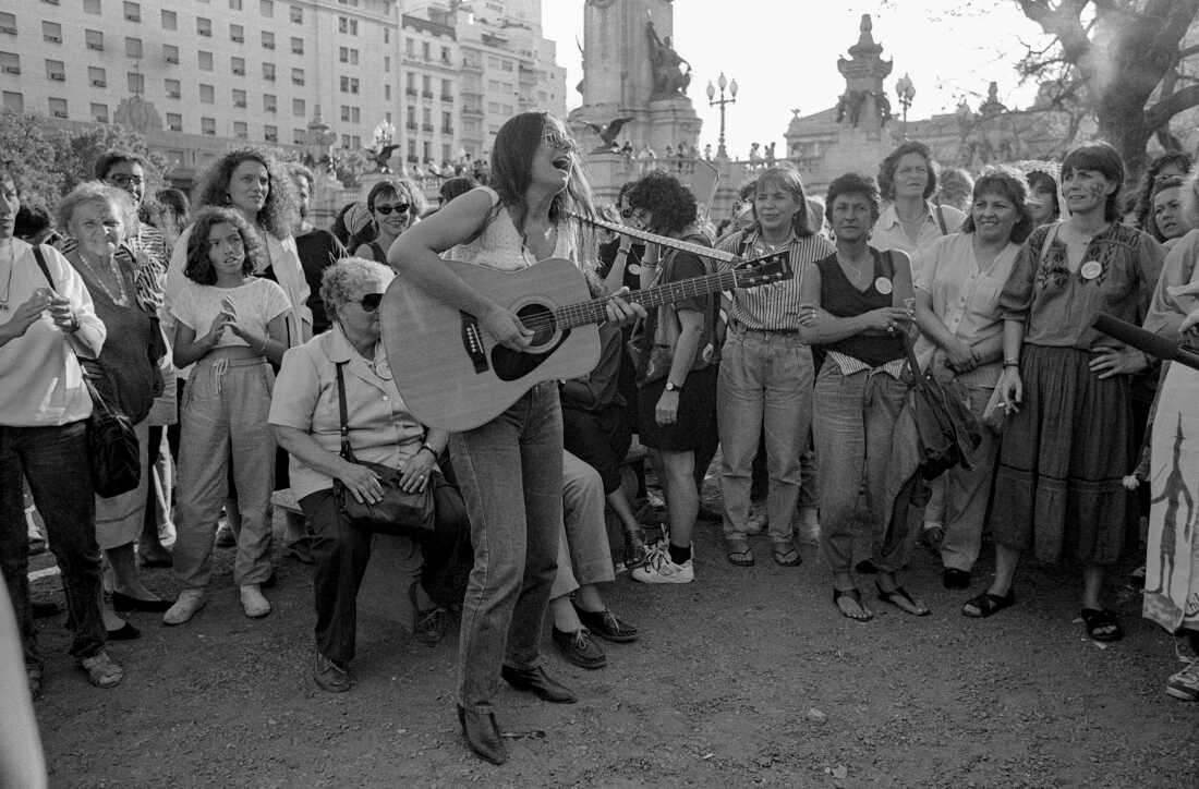 A woman plays an acoustic guitar for participants in the closing march of the 5th Encuentro Feminista Latinoamericano y del Caribe (Feminist Meeting of Latin America and the Caribbean) in San Bernardo, Argentina on November 24, 1990.
