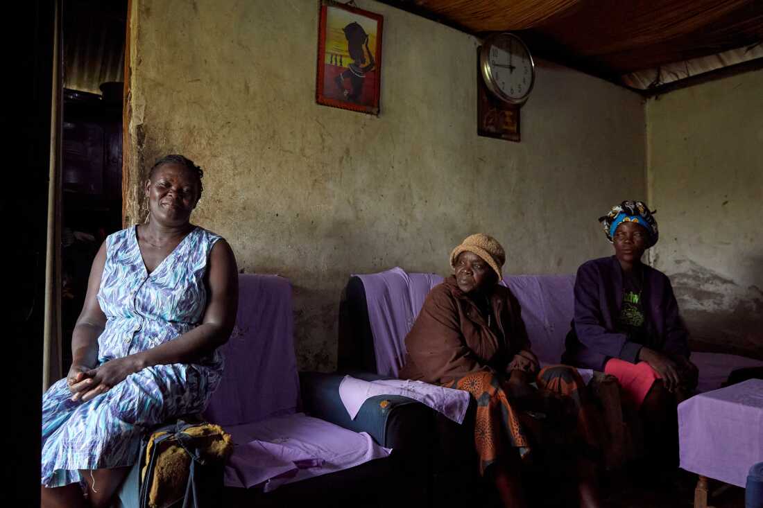 Rebbeccah Atieno, a member of the No Sex For Fish group, sits inside her current home, along with No Sex For Fish chairwoman Justine Adhiambo Obura, and fellow member Naomy Akoth, Nduru Beach, Kisumu, Kenya, 2025.