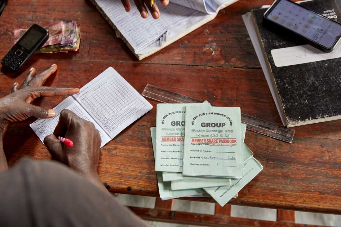 No Sex For Fish member Naomy Akoth makes notes during table banking sunday, Justine's home, Nyang’ande, Kisumu, Kenya, 2025.