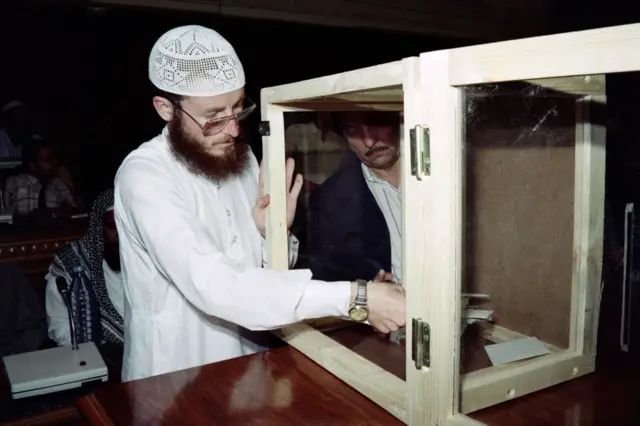 ممثل عن الجبهة الإسلامية للإنقاذ يقوم بجميع بطاقات التصويت من أحد صناديق الاقتراع، أثناء الانتخابات البلدية.