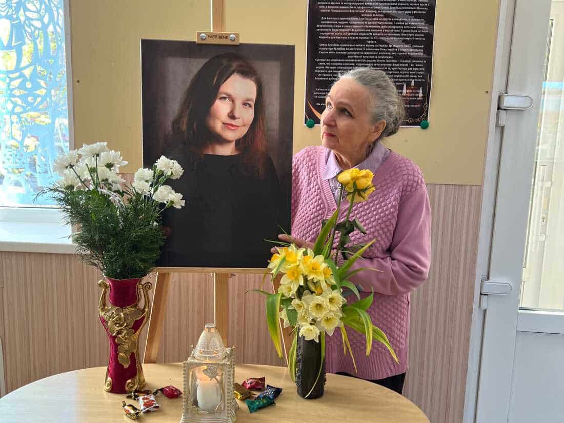 Natalia stands with a portrait of her daughter, Olena, who was killed in a Russian attack in Sumy.