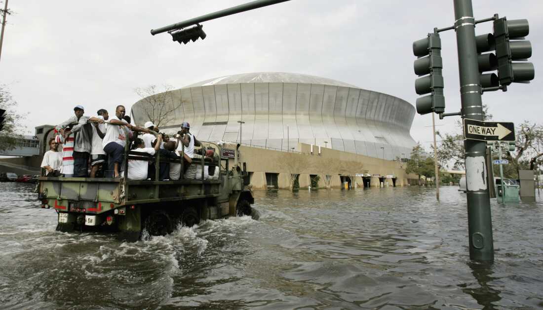 FILE - National Guard trucks haul residents through floodwaters to the Superdome after Hurricane Katrina hit in New Orleans, Aug. 30, 2005. (AP Photo/Eric Gay, File)