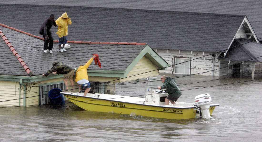 FILE - In this Aug. 29, 2005 file photo, Bryan Vernon and Dorothy Bell are rescued from their rooftop after Hurricane Katrina hit, causing flooding in their New Orleans neighborhood. The most destructive storm in U.S. history and also one of the deadliest, Katrina was a Category 3 storm with estimated maximum winds of 125 mph when it made landfall near Buras, La., on Aug. 29, 2005. Broken levees left most of New Orleans inundated. Damage was estimated at $75 billion, though rebuilding costs have far exceeded the initial damage. Katrina was blamed for around 1,200 deaths. (AP Photo/Eric Gay, File)