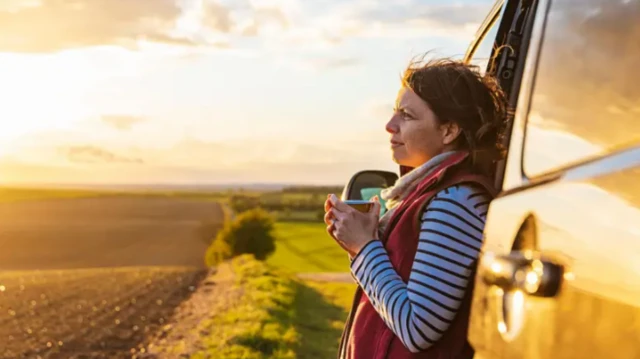 امرأة تتطلع إلى الأفق تعلو وجهها ابتسامة.