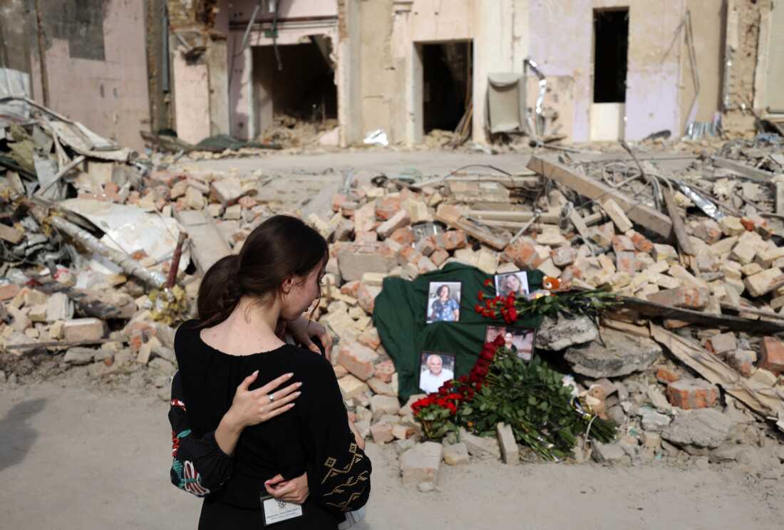Hospital workers are grieving in front of an improvised memorial with portraits of the victims displayed on the ruins of one of the medical buildings of the Okhmatdyt children's hospital destroyed by a rocket explosion, in Kyiv, on July 12, 2024, amid the Russian invasion in Ukraine.