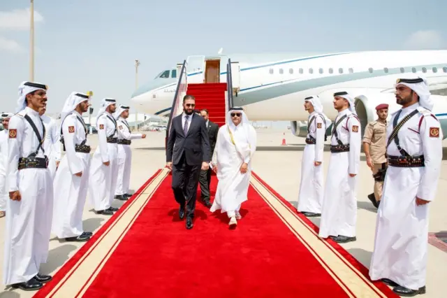 الرئيس السوري أحمد الشرع يمشي على السجادة الحمراء بعد نزوله من الطائرة في الدوحة قبل القمة العربية الإسلامية الطارئة