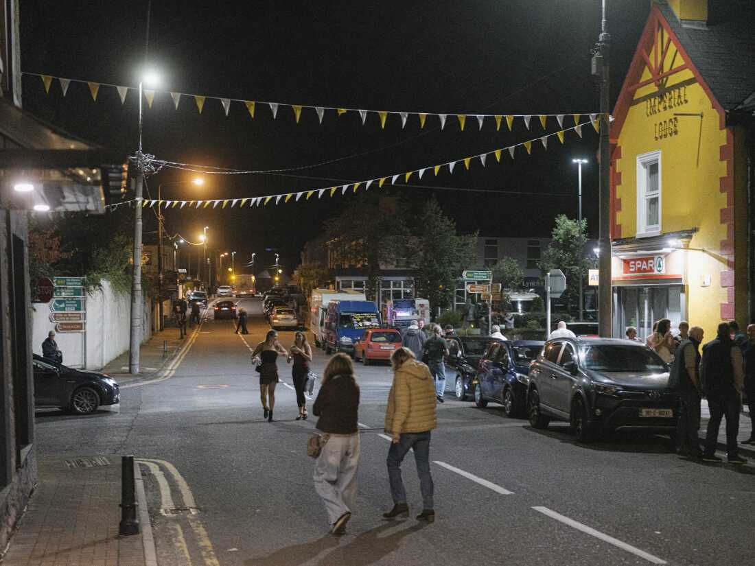 People walk across the main road during Lisdoonvarna Matchmaking Festival in Lisdoonvarna, Ireland, Sat., Sept. 27, 2025. The annual event, known as Europe’s biggest matchmaking festival, draws thousands seeking love, music and dancing. (Rob Stothard for NPR)
