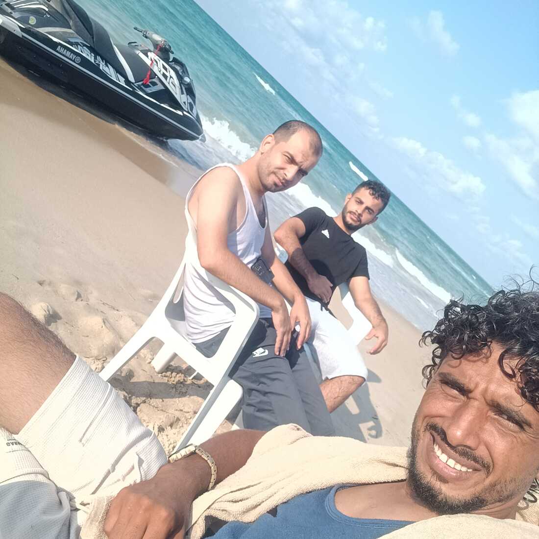Mohammed Abu Daqqa, a 31-year-old Palestinian from Gaza, poses for a selfie with two other Palestinians near Khums, Libya, Aug. 17, before taking a jet ski to Lampedusa, Italy.