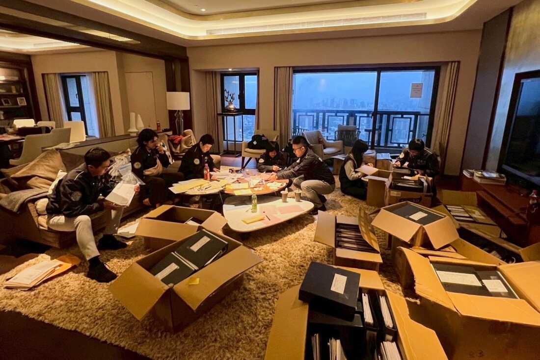 In this photo released by Ministry of Justice Investigation Bureau, Investigation Bureau agents check documents after they seized an apartment which belongs to the suspected head of a criminal scamming syndicate, in Taipei, Taiwan, Tuesday, Nov. 4, 2025.