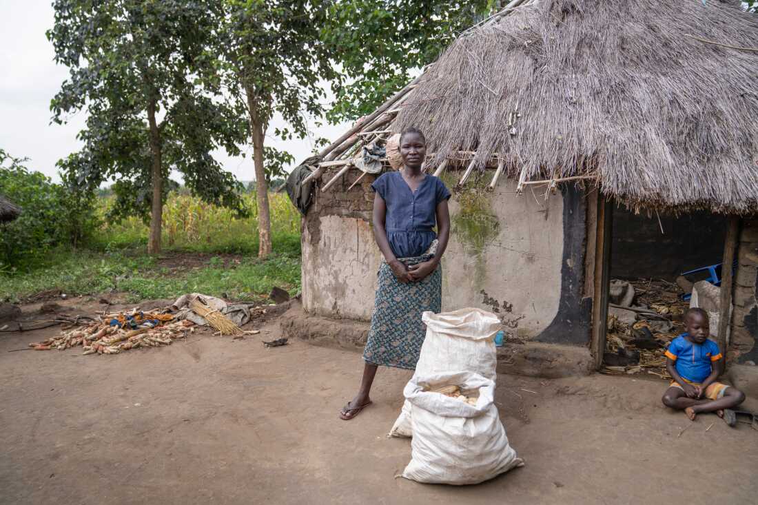 Santa Angwech shows the corn she has harvested that she says will last her family about 2 weeks before they run out.