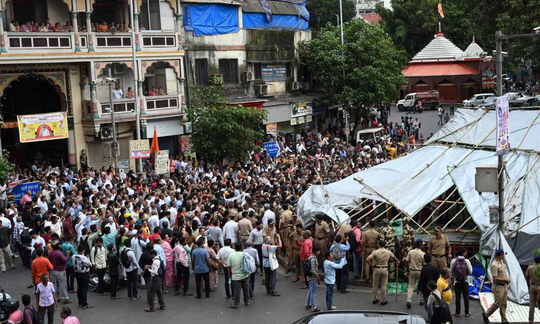 MUMBAI, INDIA - AUGUST 6: Protestors including many members of Jain community protest against the BMC's closure of the popular pigeon feeding site at Dadar on August 6, 2025 in Mumbai, India. The demonstration escalated as protestors dismantled the plastic and bamboo structures installed by civic authorities to enforce a court-ordered ban.