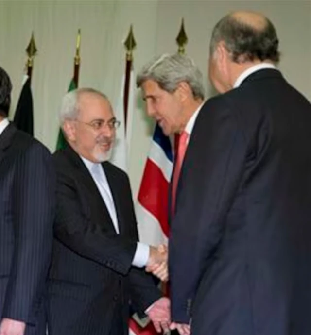 وزير الخارجية الإيراني محمد جواد ظريف، ووزير الخارجية الأمريكي جون كيري، ووزير الخارجية الفرنسي لوران فابيوس يتبادلون التحية والمصافحة في قصر الأمم بجنيف في 24 نوفمبر/تشرين الثاني 2013. 