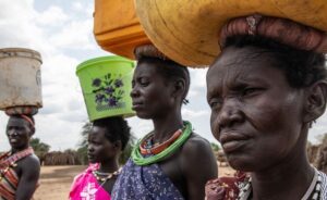 Women and children in Eastern Equatoria collecting water, showing drought risk and need for anticipatory assistance
