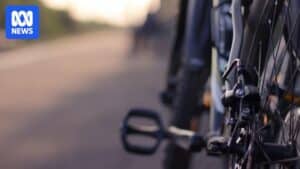 Cyclist riding on a frosty Canberra bike path wearing a puffer jacket, gloves and a balaclava