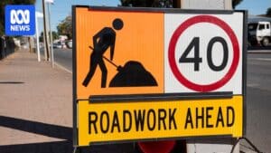 Roadwork signs and lowered speed limit signs on an ACT roadwork site