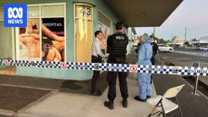 Police at a cordoned-off scene on Denham Street in Rockhampton's CBD with police tape