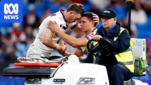 Will Warbrick leaving the field in a medi-cab after suffering a suspected Achilles injury, teammates consoling him
