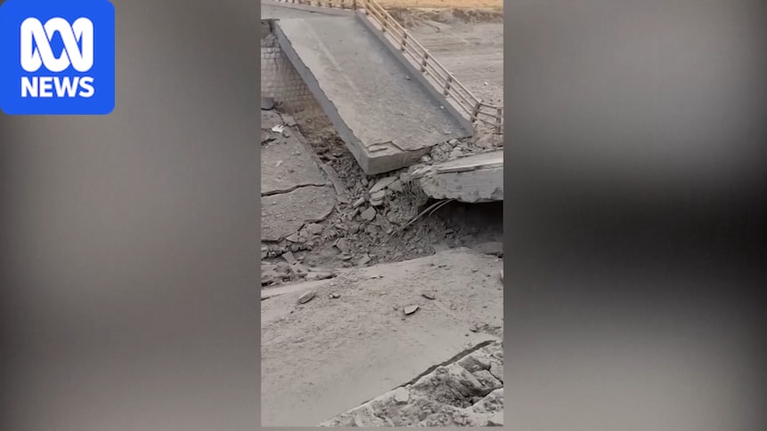 Rubble and damaged vehicle on a smashed bridge in Bandar Khamir after strikes